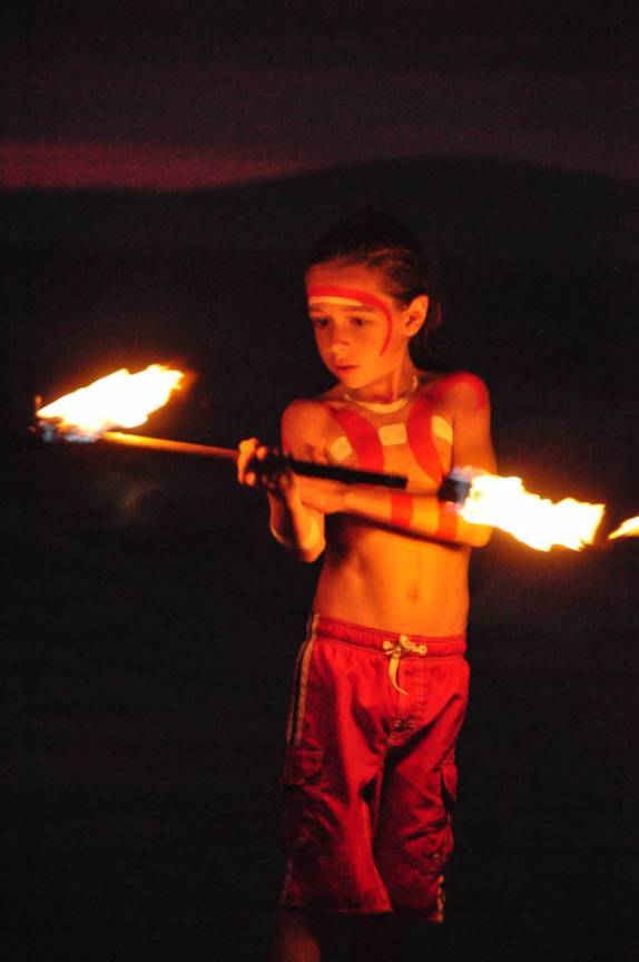 Criança faz malabarismo com fogo durante festa na praia de Little Beach, ao sul de Kihei, em Maui, no Havaí